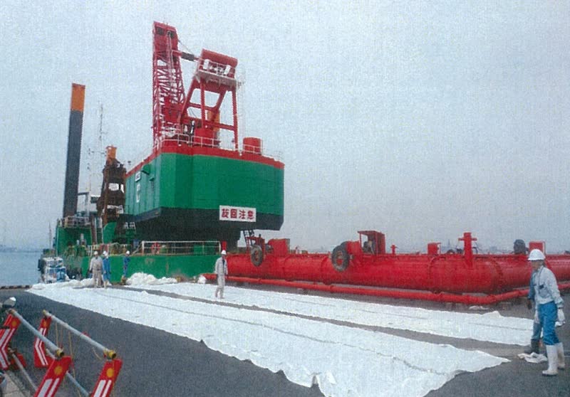 岸壁に広げられた防砂シート