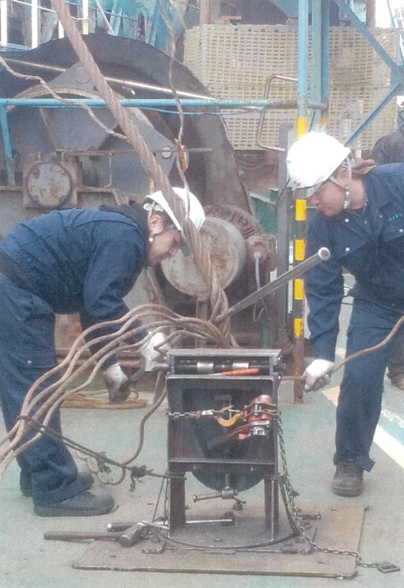 船上でワイヤーを加工する作業員